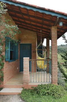 a porch with a hammock hanging from the roof and an iron fence around it