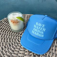 a blue hat sitting on top of a table next to a drink