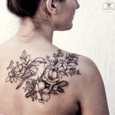 a woman with a bird and flowers tattoo on her back