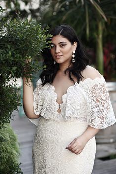 a woman in a white dress is posing for the camera