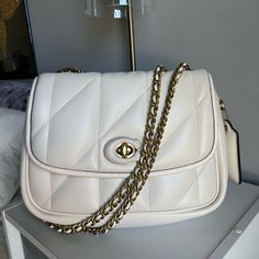 Bought Brand New A Couple Months Ago, Only Used A Handful Of Times. Minimal Wear. All Leather Is In Great Condition, With Functional Locking Clasp. Chain Strap Can Be Worn On The Shoulder, Or Crossbody By Pulling It All The Way Through The Bag. Color Is Not Crisp White, It’s More Of A Cream With Brushed Gold Metal Hardware. I Love This Bag, But I’m Selling Because I Don’t Wear It As Much As I Thought I Would. Message Me With Any Questions! Pillow Madison Coach, Coach Pillow Madison Bag, Coach Pillow Madison, Coach Pillows, Metal Hardware, Chain Strap, Coach Bags, Gold Metal, Bag Lady