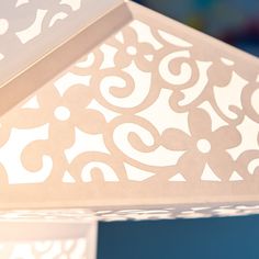 a close up of a white lamp on a blue tablecloth with an intricate design