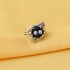 a close up of a ring on top of a yellow cloth with an evil face