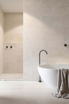 a large white bath tub sitting next to a walk in shower