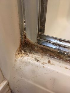 the corner of a bathroom that has been gutted with moldy paint and water