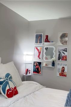 a white bed topped with pillows and pictures on the wall