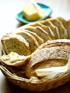 sliced bread in a basket with butter on the side