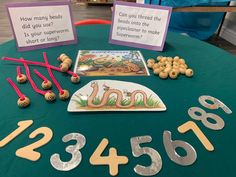 a green table topped with lots of numbers and magnets next to signs that say how many beads did you use?