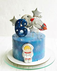 a birthday cake decorated with stars and an astronaut figure