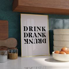 a bowl of eggs sitting on top of a counter next to a framed poster