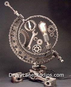 a clock made out of metal gears and wrenches on top of each other with a light bulb in the middle