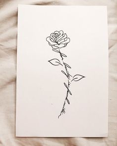 a black and white drawing of a rose on a sheet of paper with the words love written in cursive writing