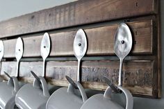 spoons are hanging from the hooks on a wall