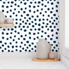 the wallpaper is blue and white with polka dots on it, as well as two vases