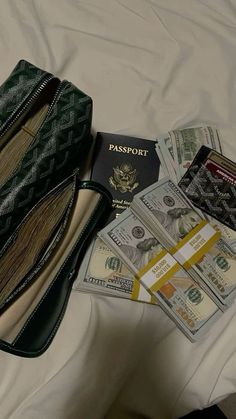 an open purse sitting on top of a bed filled with money