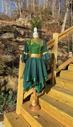 a green dress sitting on top of a wooden staircase