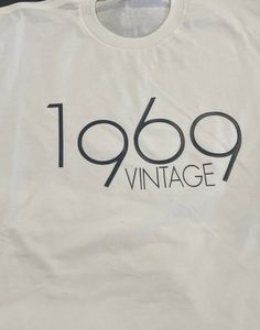 White T-Shirt "Vintage 1969" Vintage Birthday T-shirt With Text Print, Classic Graphic Print T-shirt For Birthday, Vintage White T-shirt For Birthday, Vintage Text Print Top For Birthday, Vintage Letter Print Tops For Anniversary, Retro White Tops For Anniversary, Vintage Short Sleeve Tops For Birthday, Vintage White Top For Birthday, Retro Pre-shrunk T-shirt For Anniversary