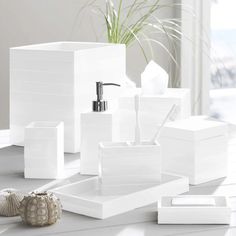 white bathroom accessories including soap dispenser and toothbrush holder