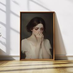 a portrait of a woman with her hands to her face in front of a white wall