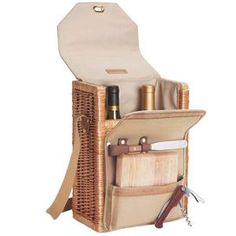 an open wicker picnic basket with wine bottles and utensils