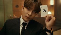 a man in a suit holding up a card