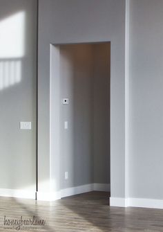 an empty room with white walls and wooden floors