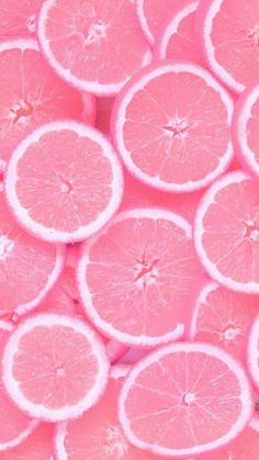 pink grapefruit slices are arranged in a large group on top of each other