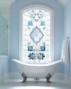 a bath tub sitting next to a window in a bathroom