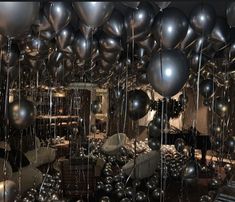 a room filled with lots of metallic balloons