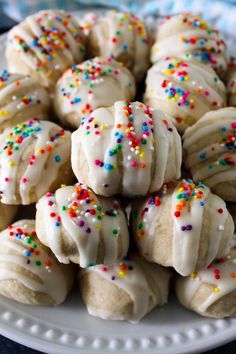 a white plate topped with cookies covered in frosting and sprinkles