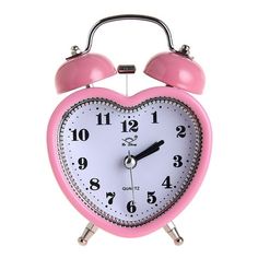 a pink and white heart shaped alarm clock with two bells on each side, against a white background