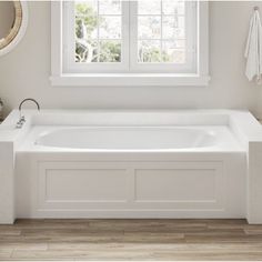 a large white bath tub sitting under a window