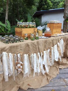 a table covered in jars filled with food next to some plants and other things on the table