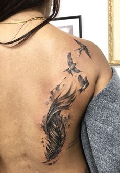 a woman with a tattoo on her back has a bird and feather feathers in flight