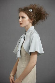 A gentle mandarin collar quietly glides into fitted shoulders before streaming into lovely draping sleeves; a luxuriously oversized bow takes in the action. Hook-n-eye closure. 100% Silk shell; acetate lining. A Hitherto original and a gorgeous addition to any wedding dress! Since it's silk, it may wrinkle when we ship it. A gentle steam will do the trick. A beautiful brand new BHLDN shawl at a great price! Brand new, never been worn. Color - Sky Blue. Also available in Ivory Draping Sleeve, Aquamarine Wedding, Fleur Delacour, Evening Shawls, Bridal Cover Up, Anthropologie Wedding, Cape Jacket, Wedding Dresses Romantic, Wedding Dresses Vintage