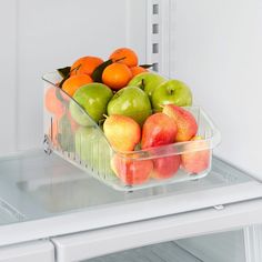 a container filled with lots of fruit sitting on top of an open refrigerator