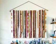 there is a wall hanging made out of many different colored ribbons and beads on the wall