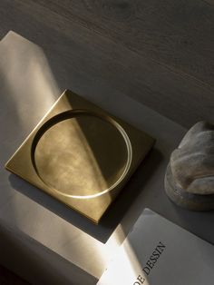 a gold plate sitting on top of a wooden table next to a pair of shoes