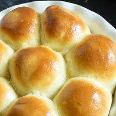 a white bowl filled with rolls on top of a table