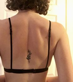 the back of a woman's bra with a flower tattoo on her left side