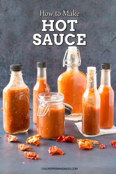 several bottles filled with sauce sitting on top of a table