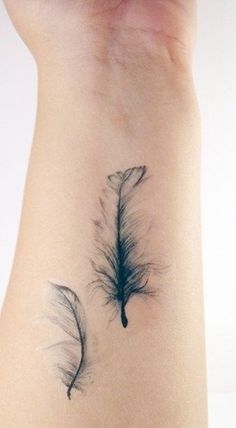 the back of a woman's stomach with two feathers on it