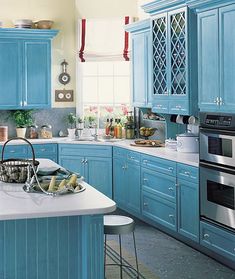 a kitchen with blue cabinets and white counter tops