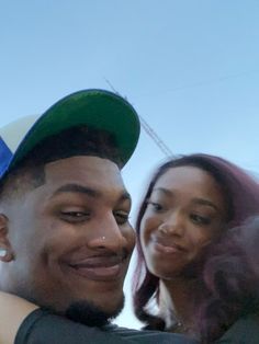 a young man and woman taking a selfie with the sky in the back ground