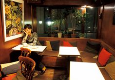 a woman sitting at a table in a restaurant