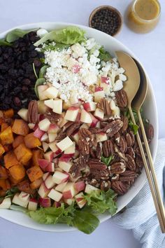 a salad with apples, pecans, raisins and cheese