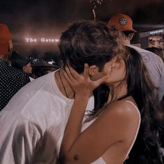 a man and woman kissing in front of fireworks