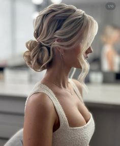 a woman with blonde hair in a white dress and earrings is looking off to the side