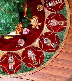 a christmas tree is surrounded by candy candies on a red tablecloth with gold trim