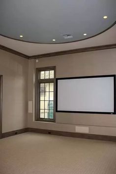 an empty room with a large screen on the wall and no one in it yet